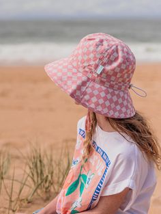 Bucket hat with a gorgeous dusty pink and cream checks deisgn on the outside and on the inner brim. Elasticated toggle around the head for the perfect fit. Cord and toggle under the chin to keep the hat in place. Wide brim (Measures for each size S: 6cm, M: 6.5cm, L: 7cm, XL: 7.5cm). Material: 100% Cotton including lining. Tested and certified as UPF50+ sun protection. Checks Design, Acorn Kids, Kids Sun Hat, Sleep Gifts, Baby Bloomers, Baby Bundles, Tiny Cottons, Wool Beanie, Kids Boutique