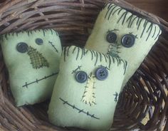 three pillows with faces are sitting in a basket