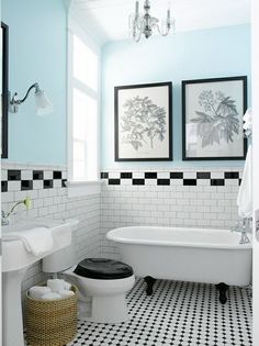 a bathroom with black and white checkered flooring, two pictures on the wall