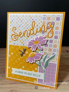 a handmade card with flowers and the words sending on it, sitting on a wooden table