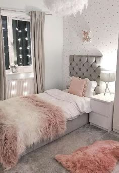 a bedroom decorated in white and pink with fluffy fur rugs on the floor, windows, and bed