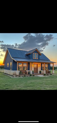 a large blue house sitting on top of a lush green field