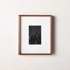 a black and white photo hanging on the wall next to a wooden frame with people in it