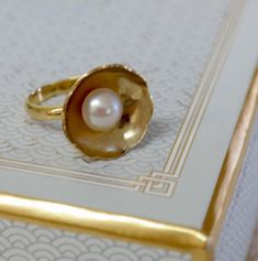 If a picture is worth a thousand words, then this elegant  Big Flower gold plated ring with a classic pink pearl says much more than a thousand words about its wearer. All eyes will be drawn to your gold plated ring, available in US sizes 5,6, 7 and 8 Can be Ordered with a white pearl ,black or a pink pearl (as seen in picture).Or can be made to order in any size. Please note your desired size in the message to seller area at checkout. This ring comes in a beautiful gift box. Each ring is made t Elegant Ring For Anniversary Gift, Heirloom Style Gold Pearl Open Ring, Heirloom Gold Pearl Open Ring, Heirloom Rose Gold Pearl Ring Gift, Heirloom Pearl Open Ring As Gift, Gold Hallmarked Pearl Ring For Gift, Gold Pearl Rings As A Gift, Gold Pearl Drop Rings As A Gift, Gold Rings With Pearl Drop For Gift