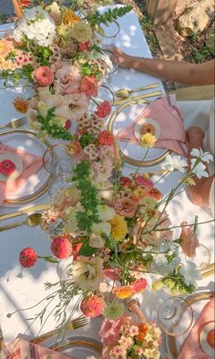 the table is set with flowers and plates