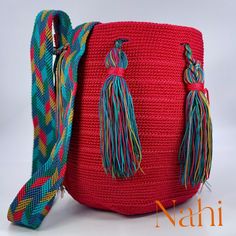 a crocheted bag with tassels on the handles and handle is shown