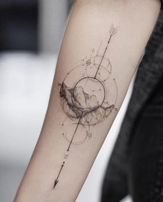 a woman's arm with an arrow tattoo on it