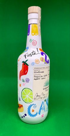 a bottle that is sitting on a green surface with the words fiesta written on it