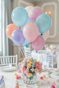 a vase filled with lots of balloons sitting on top of a white table covered in confetti