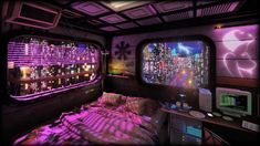 a room with a bed, television and windows in it that have city lights on them