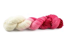 three skeins of yarn in pink, white and red on a white background