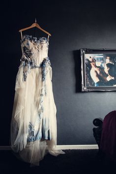 a dress hanging on a hanger next to a painting