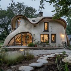 an unusual house is shown in the middle of a yard with stepping stones leading up to it