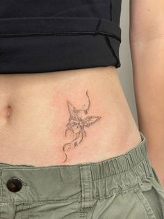 a woman's stomach with a small tattoo on the side of her belly,