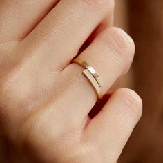 a person's hand with a gold ring on their left finger and the other hand holding