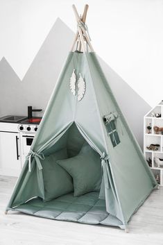 a teepee tent with pillows in front of it