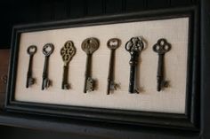 there are many old keys on display in the shadow box that is hung on the wall