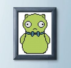 a cross - stitch picture of a green teddy bear wearing a bow tie and looking angry