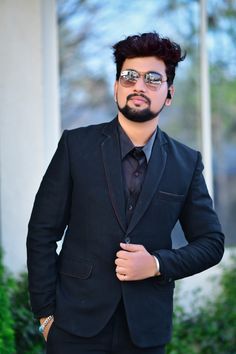 a man in a black suit and sunglasses