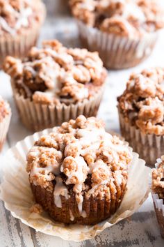 several muffins with icing on them sitting on a table