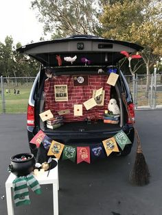 the back end of a van is decorated with cards and brooms for halloween decorations