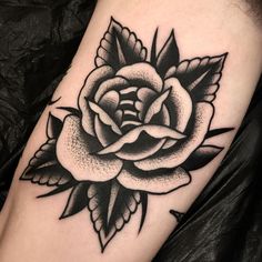 a black and white rose tattoo on the leg