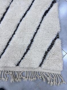 a rug with black and white stripes on the floor next to a pair of shoes