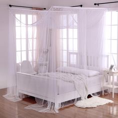 a white bed sitting on top of a hard wood floor