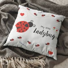 a ladybug pillow sitting on top of a blanket