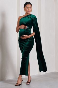 For a stunning maternity look that will always be remembered. take a look at our gracious Amaryllis gown. This green bodycon dress is made from a premium stretch velvet that's partially-lined for comfort and support. Finished with a sweeping cape sleeve and a split skirt. this asymmetric maxi dress deserves a place in your maternity wardrobe. Features - Premium stretch velvet- Asymmetric neckline- Single cape sleeve- Invisible zip closure - Bodycon fit - Bump ruching- Split hemline- Maxi length Emerald Green Formal Dress, Dress With Cape, Green Bodycon Dress, Green Formal Dresses, Maternity Wardrobe, One Shoulder Maxi Dress, Club L London, Pregnancy Looks, Pregnancy Wardrobe