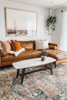 a living room with a couch, coffee table and potted plant