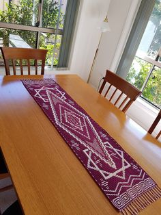 a wooden table topped with a purple runner