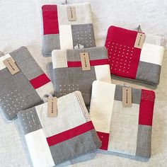 four pieces of gray and red fabric with tags on them sitting next to each other