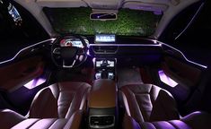 the interior of a car with blue lights and leather seats, including an entertainment center