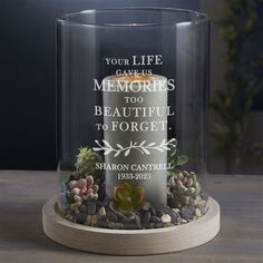 a clear glass candle with an inscription on it