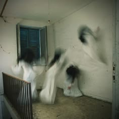 three women in white dresses are running down the stairs and one is holding her hands up