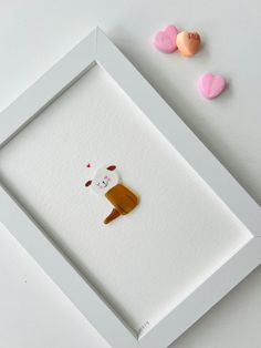 a white frame with some candy hearts and a bear cut out on the inside of it