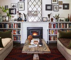 a living room with two couches and a fire place in the middle of it