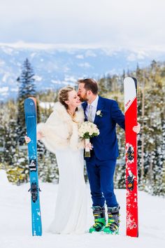 a bride and groom kissing in the snow with their skis leaning against each other