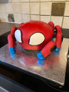 a cake shaped like a spider man sitting on top of a stove