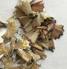 a pile of burnt wood shavings sitting on top of a white surface