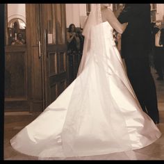 a bride and groom standing in front of an open door