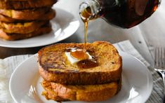 toasted french toast with butter and syrup being poured onto it on a white plate