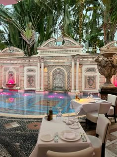 an outdoor dining area with tables, chairs and umbrellas next to a swimming pool