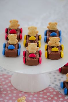 there are many small toy cars made to look like teddy bears on a cake plate