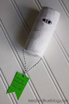 a roll of toilet paper hanging from a string with a green tag attached to it