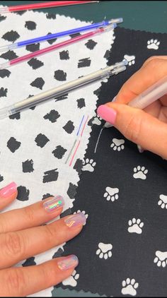 a woman with pink nail polish is working on her nails and holding a pencil in one hand