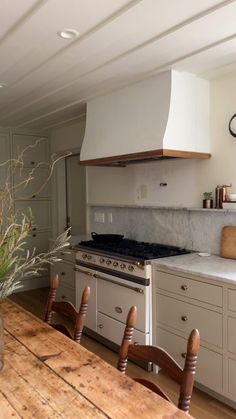 a kitchen with an oven, stove and dining room table in it's center