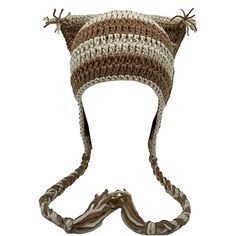 a brown and white knitted hat on top of a head with two braids