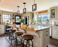 a large kitchen with lots of counter space and stools in front of the island